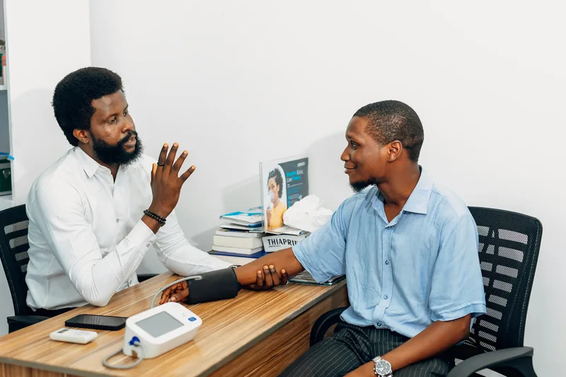 Two men in business attire seated across a desk, engaged in a professional consultation meeting