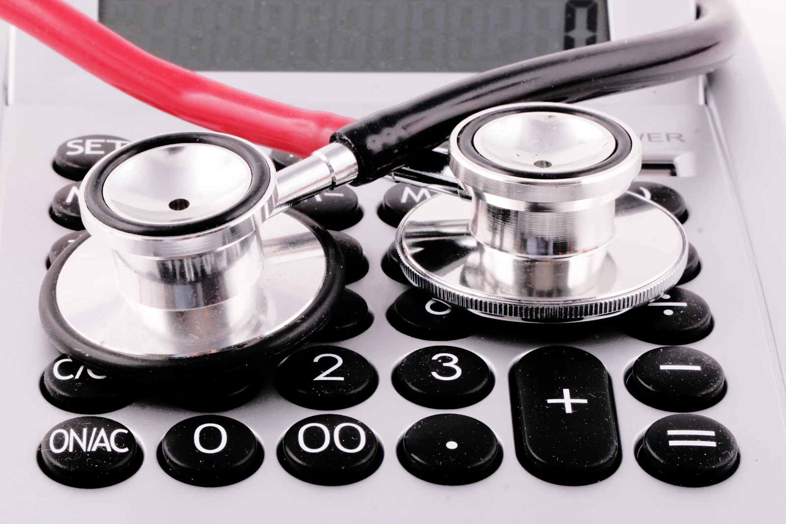 Stethoscope resting on a calculator, representing home care software pricing math