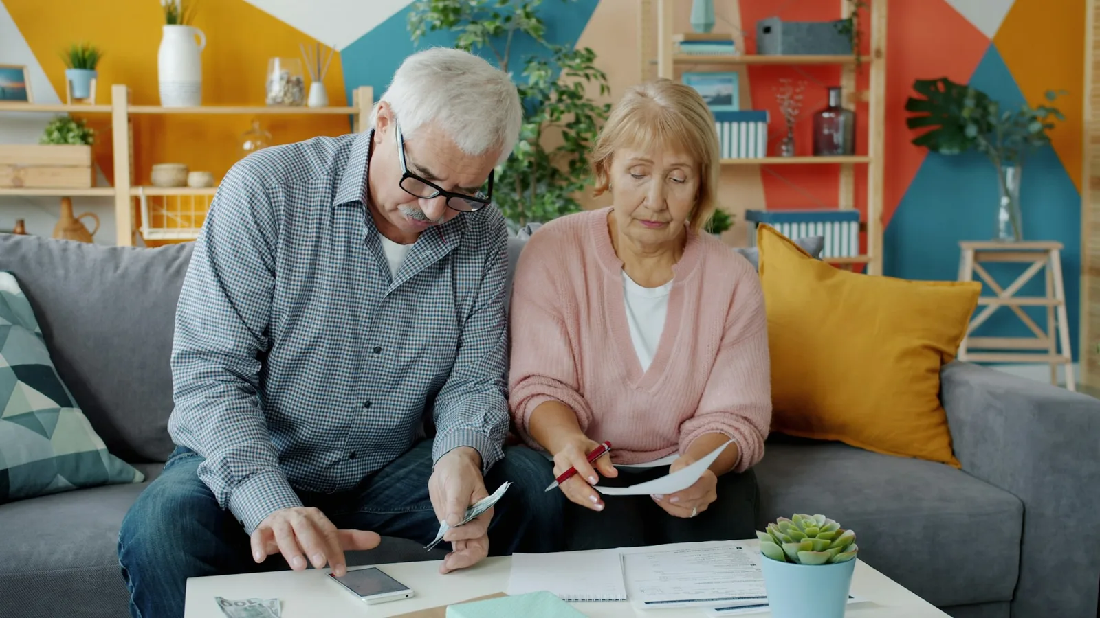Older couple seated at a home table reviewing insurance documents together