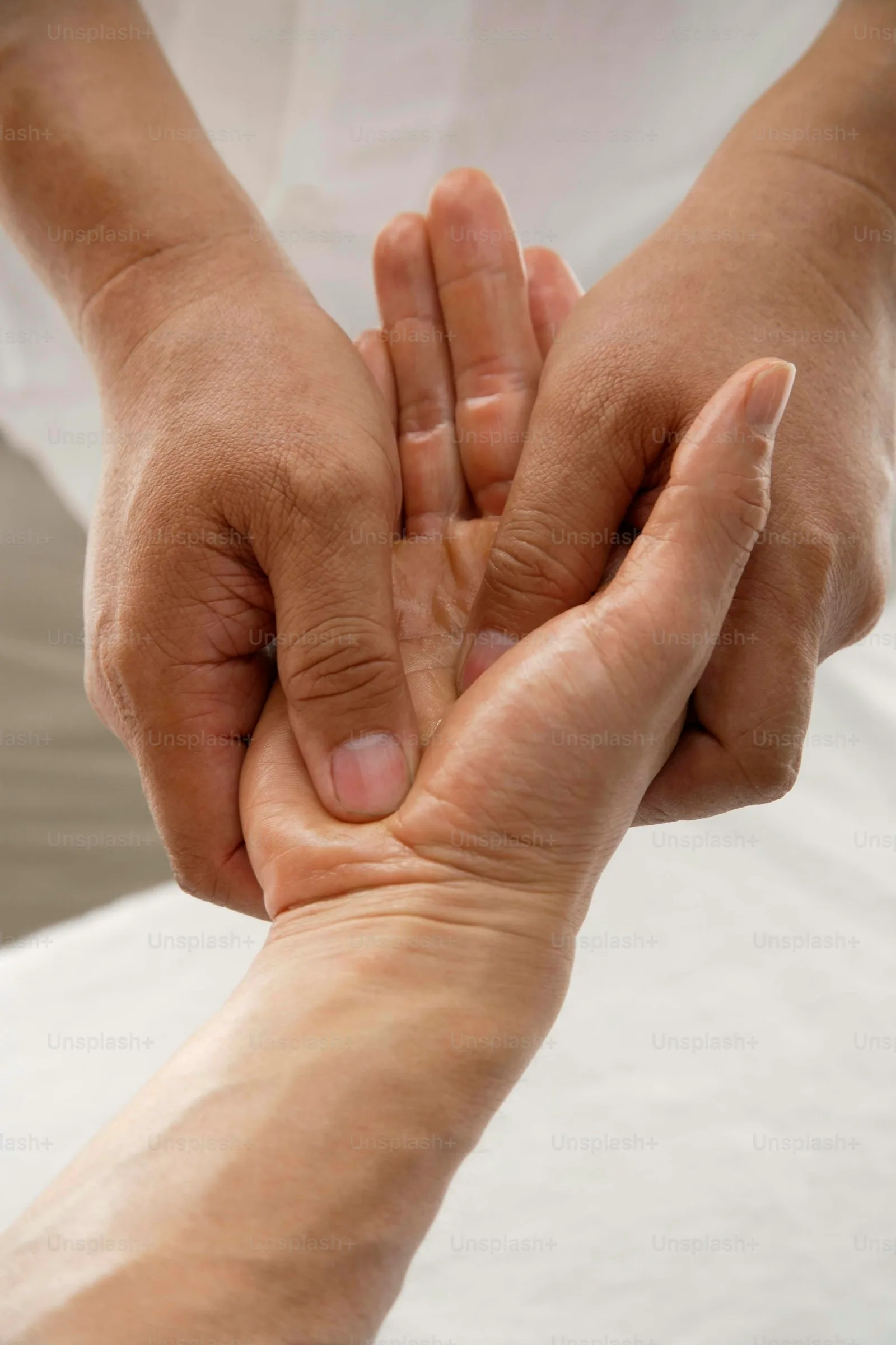 A caregiver gently holding the hand of a person recovering from a stroke