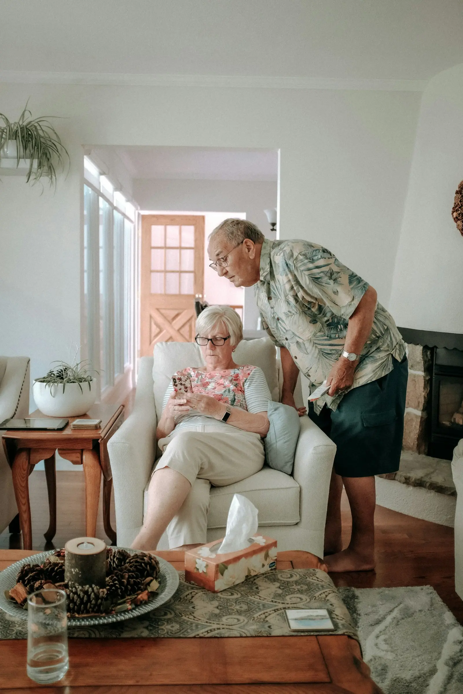 A woman and an older man seated together in a living room, engaged in a calm and attentive conversation