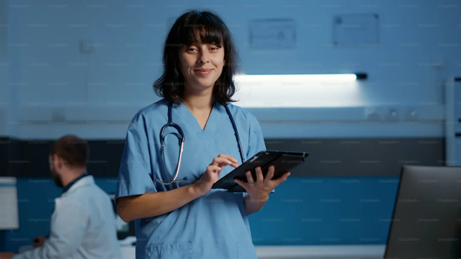 Nurse typing clinical documentation on a laptop at a desk during a night shift